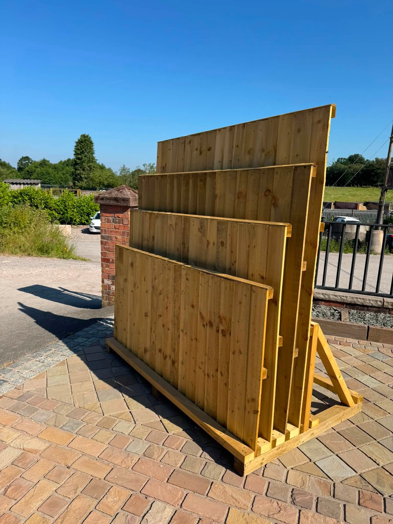 Timber fence panels on a display rack in the yard on a sunny day