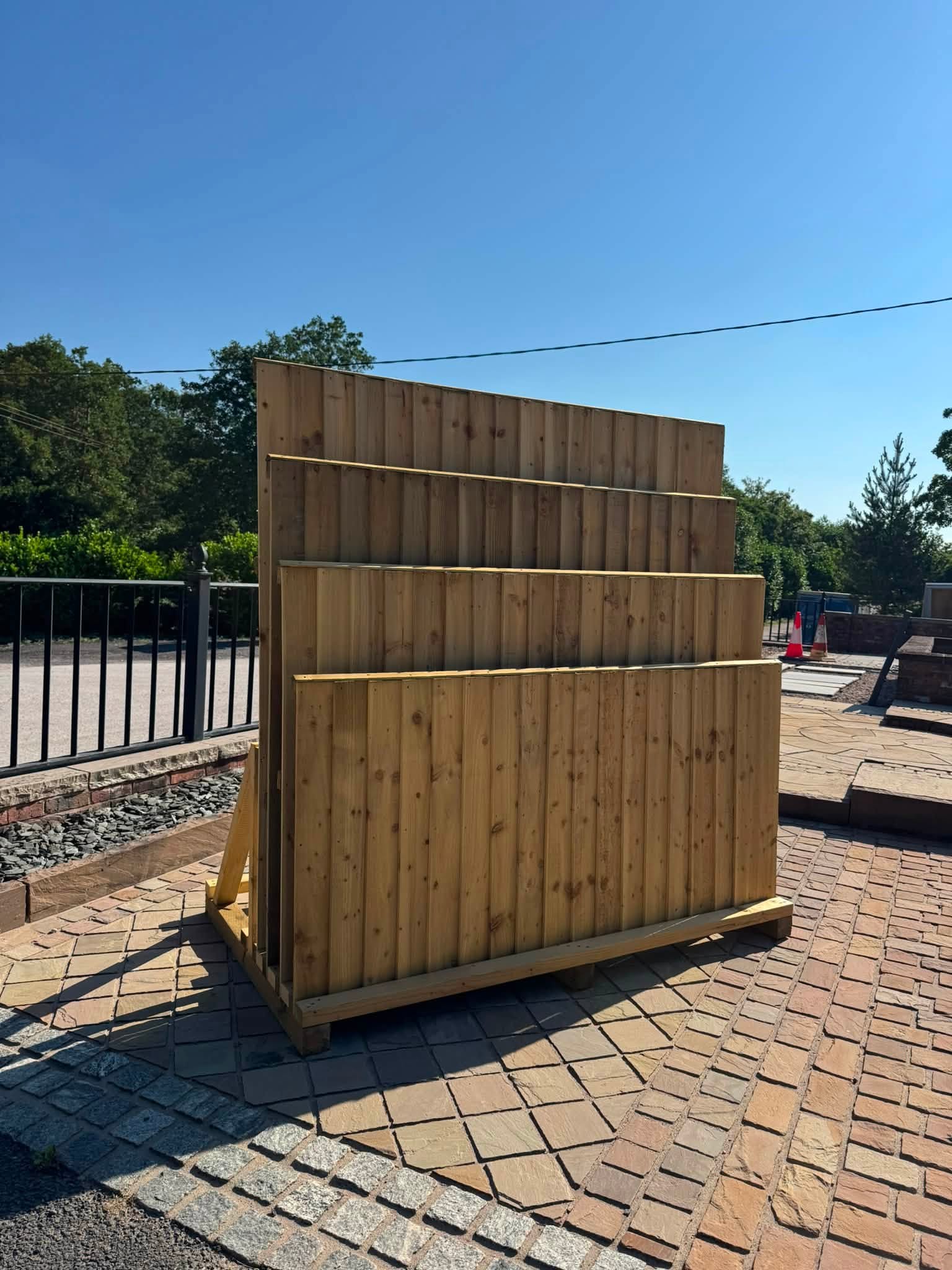 The same timber display rack seen from the paved yard, with trees beyond