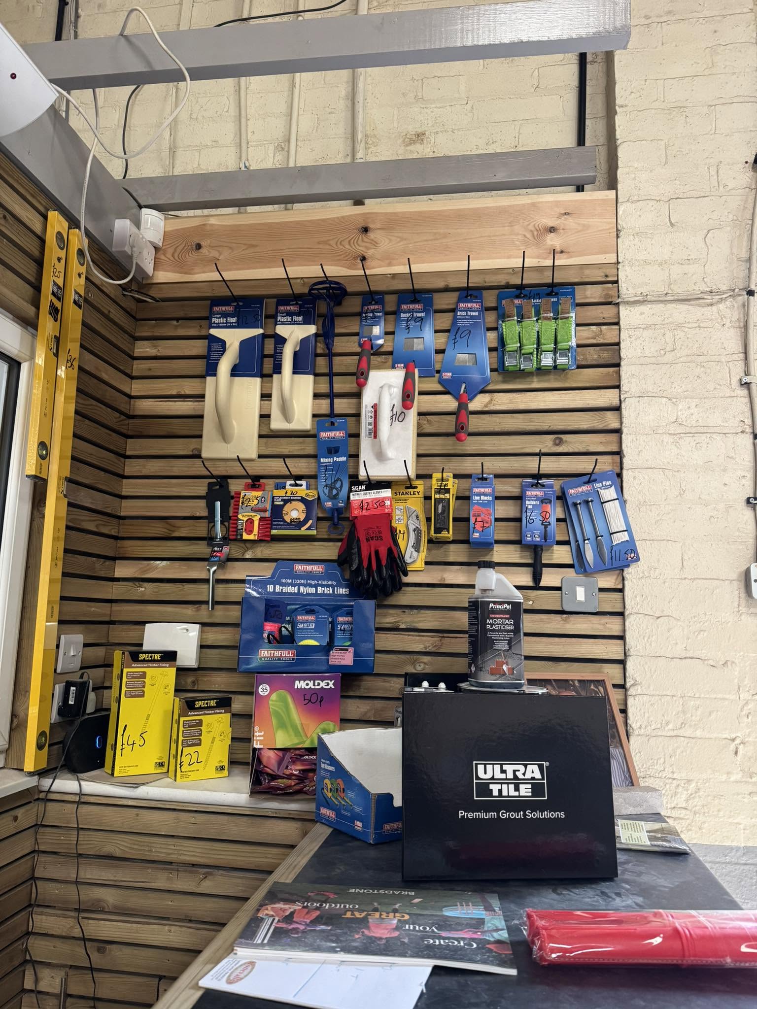 A display wall of hand tools, trowels, gloves and landscaping sundries